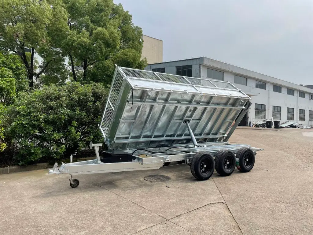 Silver tipper trailer in front of a building