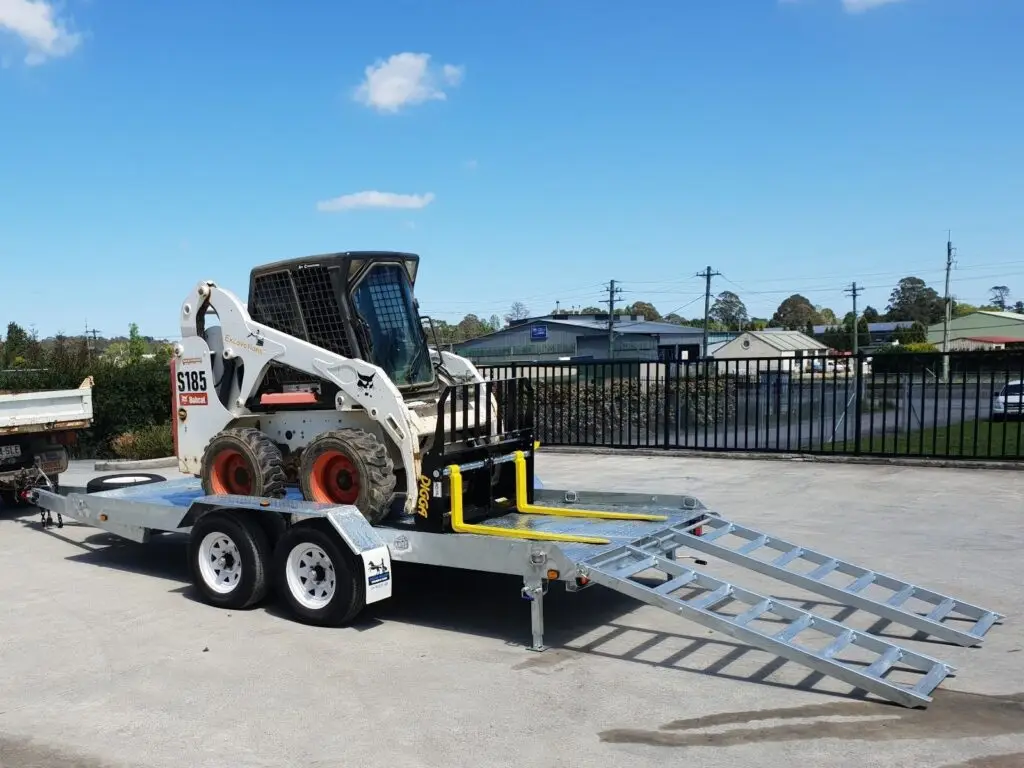 Silver trailer hauling a forklift.